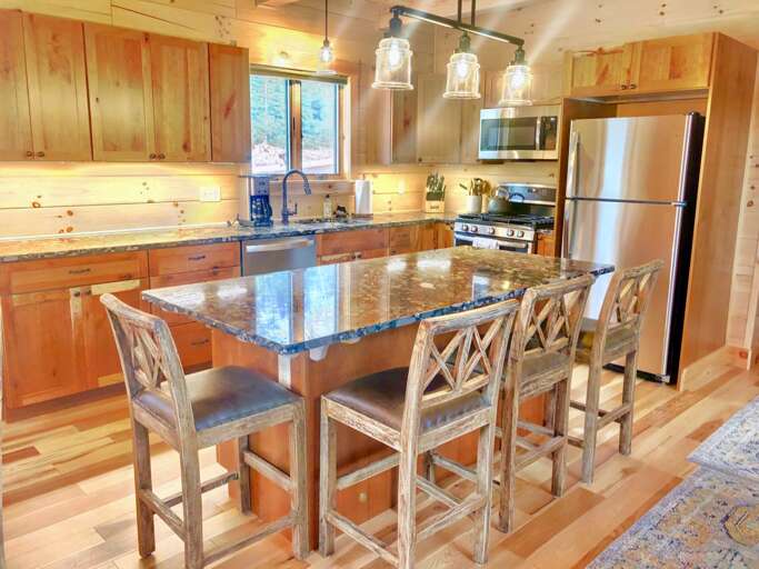 The kitchen has a warm, rustic and fully stocked for all your cooking needs! Offers a drip coffee maker, River Rock granite countertops and center island that seats 4.