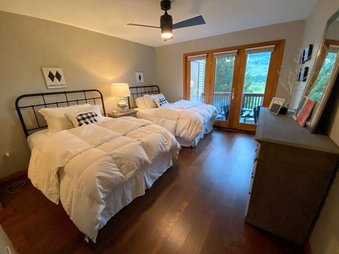 Main level bedroom with two full beds and ensuite full bath