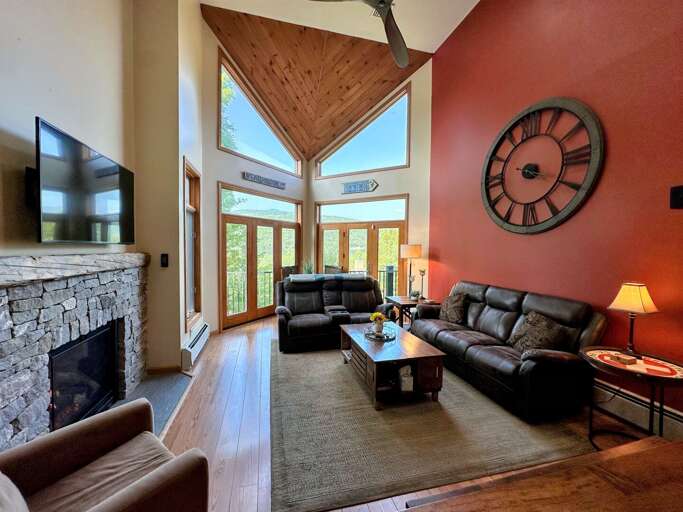 Main Level Living Area with gas fireplace, TV, deck access and adjacent to kitchen and dining area
