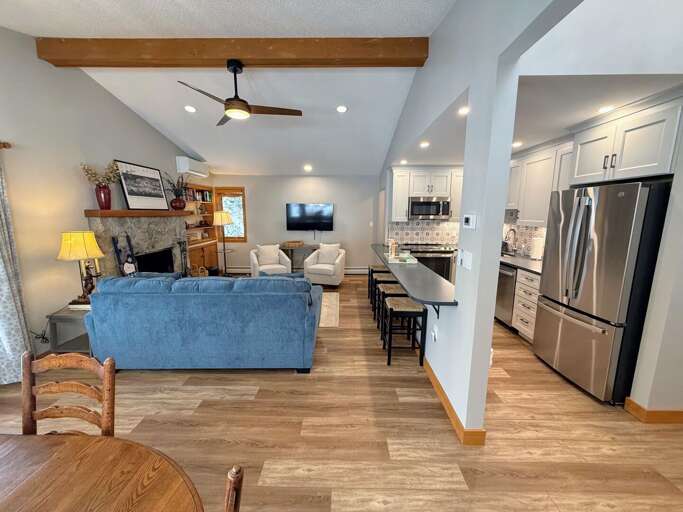 Dining/Living Area: Open concept space with cozy dining table that seats 4 and comfortable furniture that surrounds the stone fireplace.