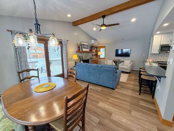 Dining/Living Area: Open concept space with cozy dining table that seats 4 and comfortable furniture that surrounds the stone fireplace.