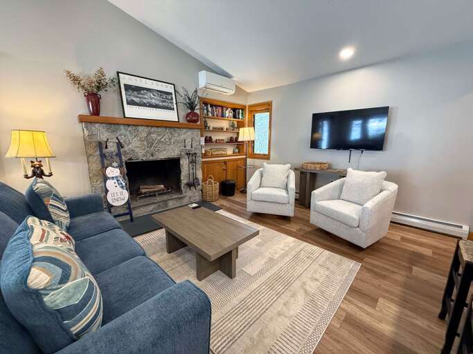 Dining/Living Area: Open concept space with cozy dining table that seats 4 and comfortable furniture that surrounds the stone fireplace.