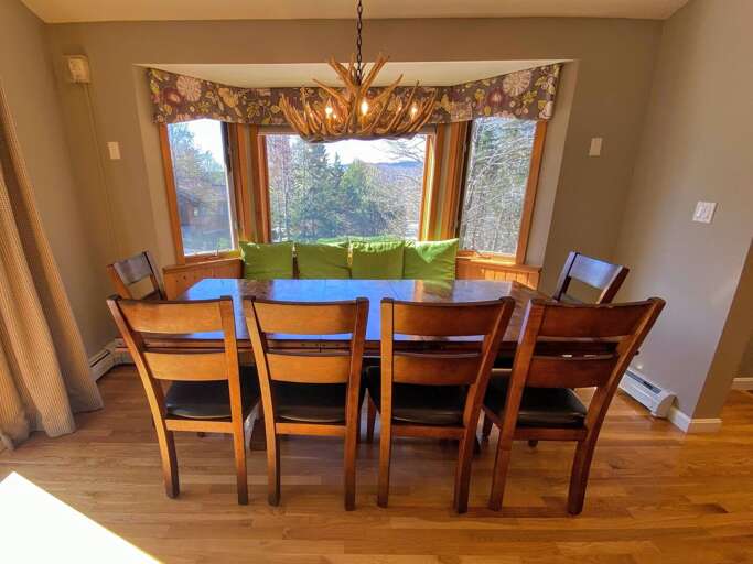 Living/Dining Area: Beautiful open concept space with large dining table that seats 10 and modern, comfortable furniture that surrounds the impressive stone fireplace.