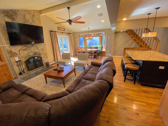 Living/Dining Area: Beautiful open concept space with large dining table that seats 10 and modern, comfortable furniture that surrounds the impressive stone fireplace.