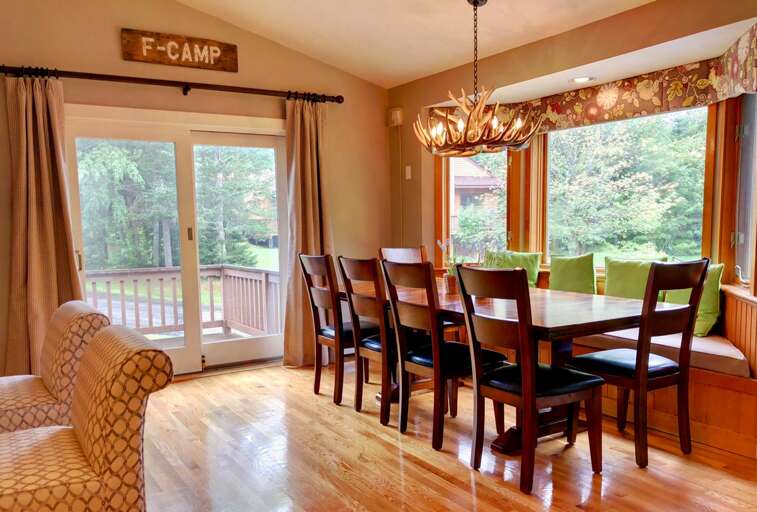 Living/Dining Area: Beautiful open concept space with large dining table that seats 10 and modern, comfortable furniture that surrounds the impressive stone fireplace.