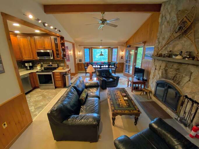 Main living area with wood burning fireplace and TV