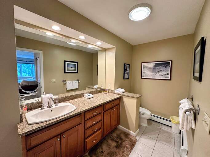 Large ensuite bathroom features granite countertops with a shower/tub combo.