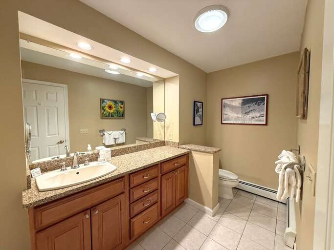 Large ensuite bathroom features granite countertops with a shower/tub combo.