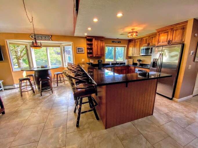 The kitchen has a large breakfast bar with granite countertops that seats 4.