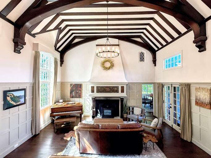 The show-stopping Great Room features a soaring timber ceiling and a functional baby grand piano