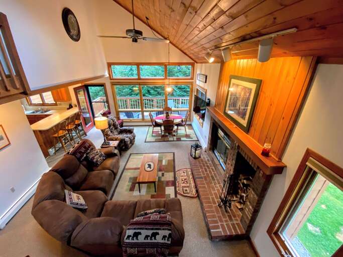 The dining/living area has a sunny open concept space with large dining table that seats 6 and comfortable furniture that surrounds the wood-burning stone fireplace. The dining/living area has a sunny open concept space with large dining table that seats 6 and comfortable furniture that surrounds the wood-burning stone fireplace.