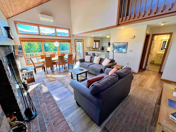 Spacious Split-level Living Space With Sofas, Fireplace, And Large Windows Spacious Split-level Living Space With Sofas, Fireplace, And Large Windows
