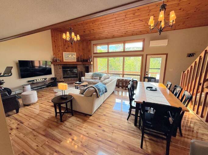 The open-concept living and dining area is anchored by a charming brick wood-burning fireplace, making it the ideal place to unwind after a day of exploring.
