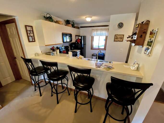Interior Of A Kitchen With Bar Stools And Dining Area