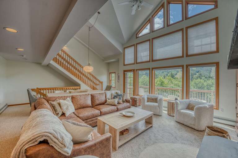 The main level boasts a bright and airy open-concept kitchen, dining, and living area with soaring ceilings and rustic-chic charm