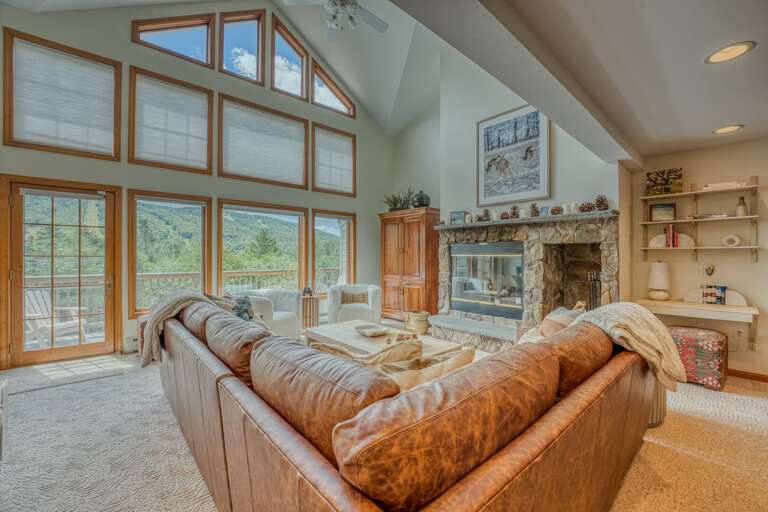 The main level boasts a bright and airy open-concept kitchen, dining, and living area with soaring ceilings and rustic-chic charm