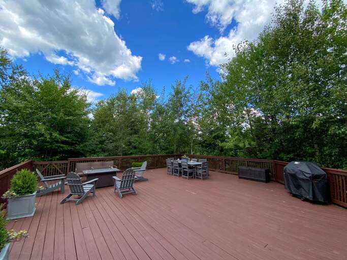 Large private deck with outdoor dining table, propane fire table, and propane grill