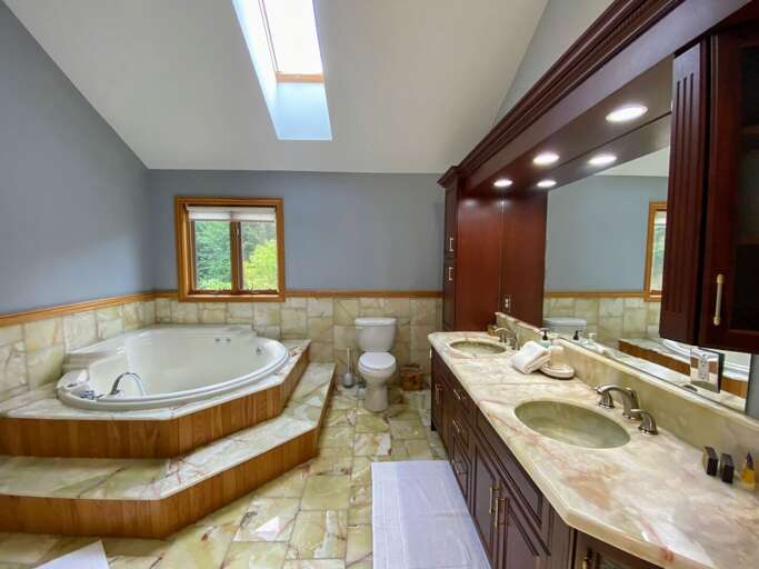 Upper level King bedroom private bath with double vanity, tub and shower