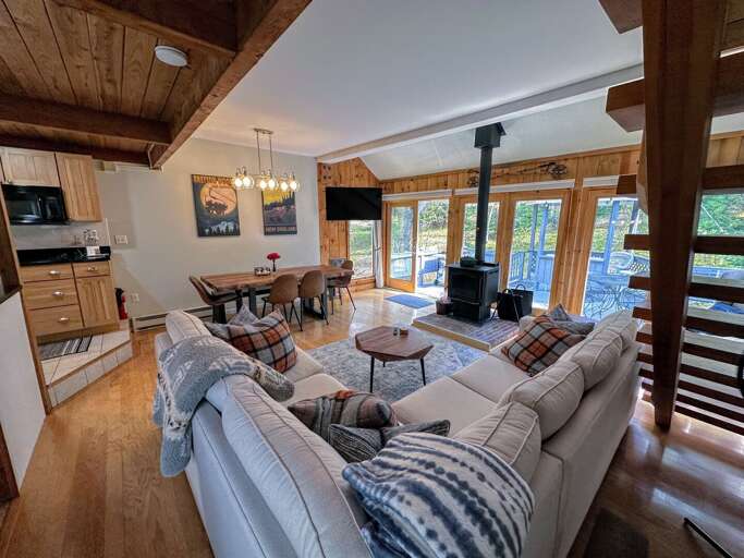 Main living area with dining table, sectional, fireplace and lots of windows!