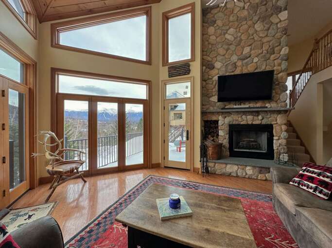 Living Room With Fireplace And Mountain View Through Large Windows Living Room With Fireplace And Mountain View Through Large Windows