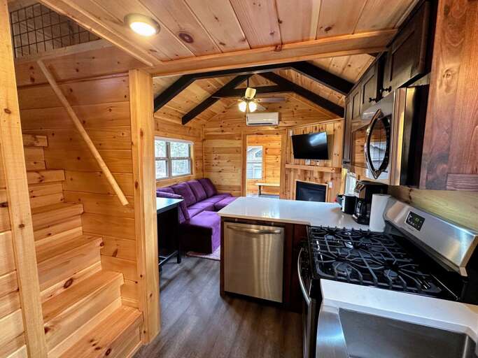 Steps in the kitchen area lead up to a low-height loft with two twin beds.