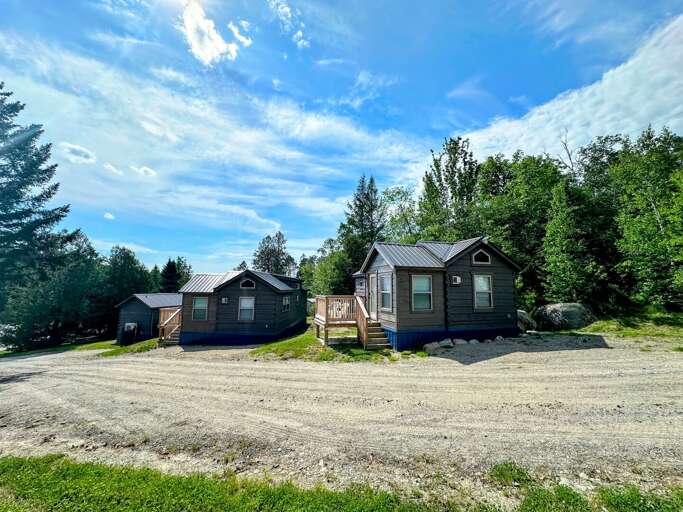 Rural Cabins Surrounded By Trees Under Blue Sky