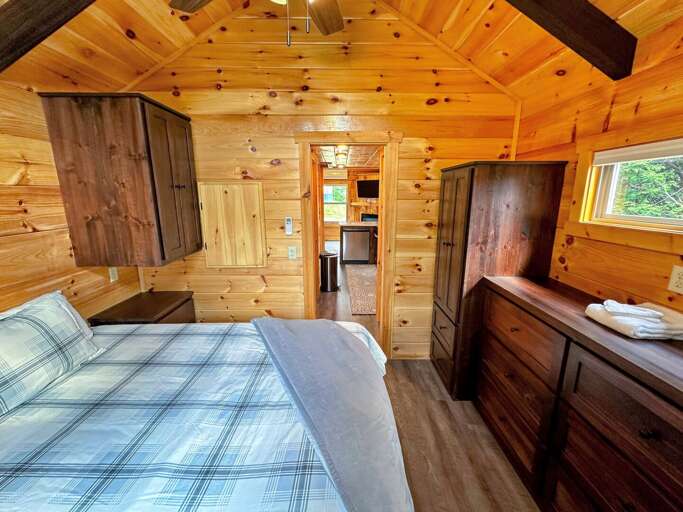 The main bedroom is past the kitchen and bathroom and has a queen bed. The main bedroom is past the kitchen and bathroom and has a queen bed.