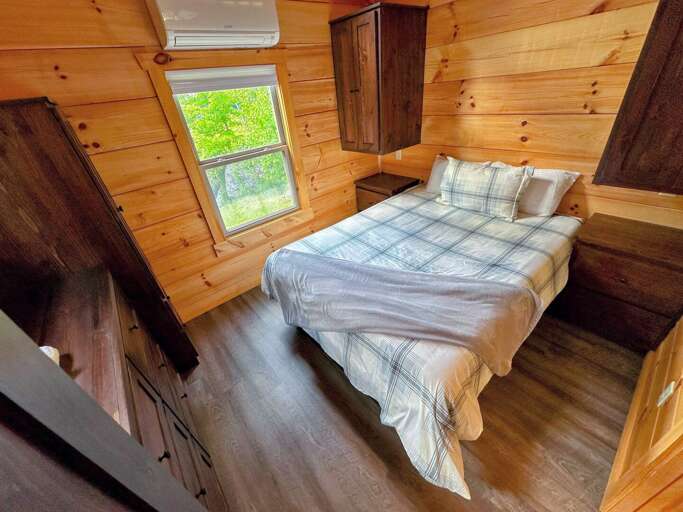 The main bedroom is past the kitchen and bathroom and has a queen bed. The main bedroom is past the kitchen and bathroom and has a queen bed.