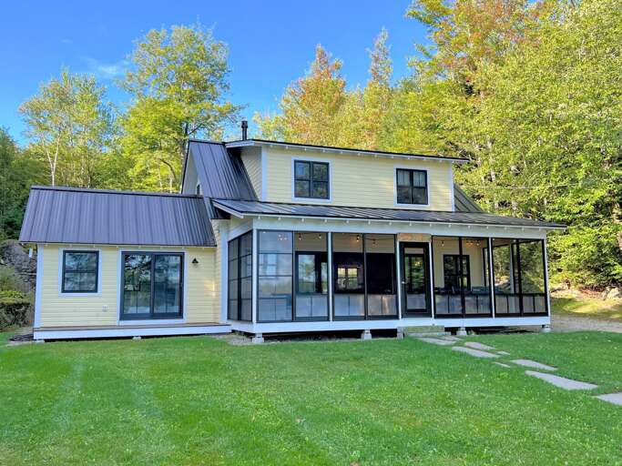 Two-story House With Screened Porch Surrounded By Trees