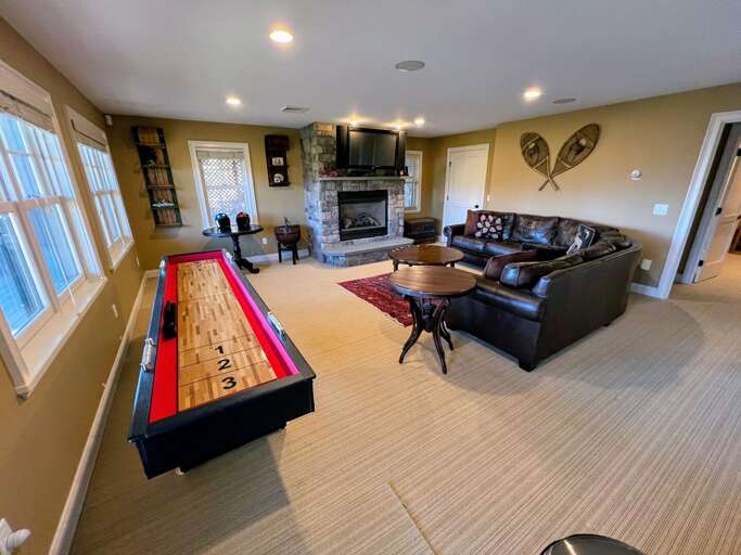 Lower level living area with shuffleboard, gas fireplace and TV