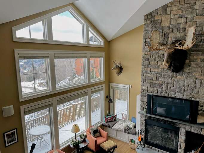 Living Room With Fireplace And Large Windows Showing Snowy Exterior Living Room With Fireplace And Large Windows Showing Snowy Exterior