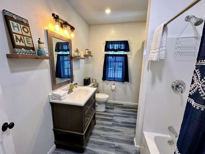 Shared full bath with shower/tub combo and laundry