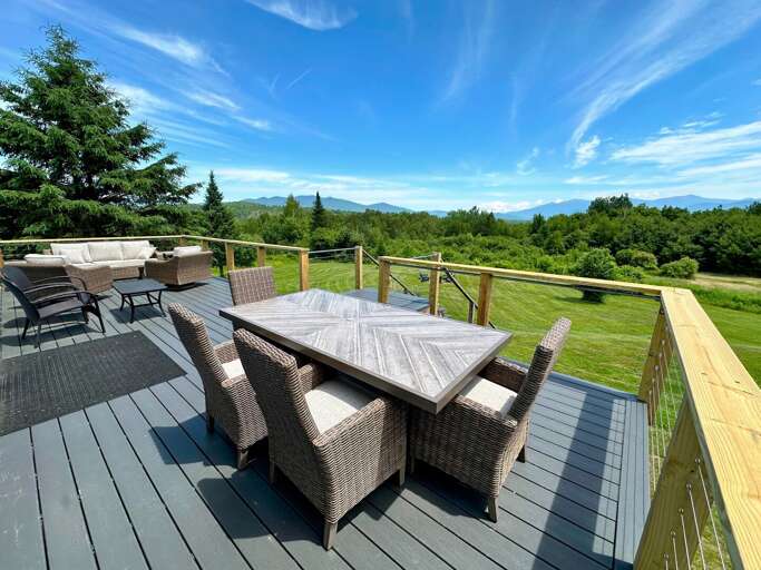 Back deck with sitting area, and dining table.