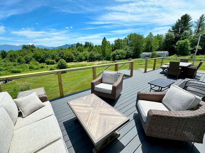 Back deck with sitting area, and dining table.