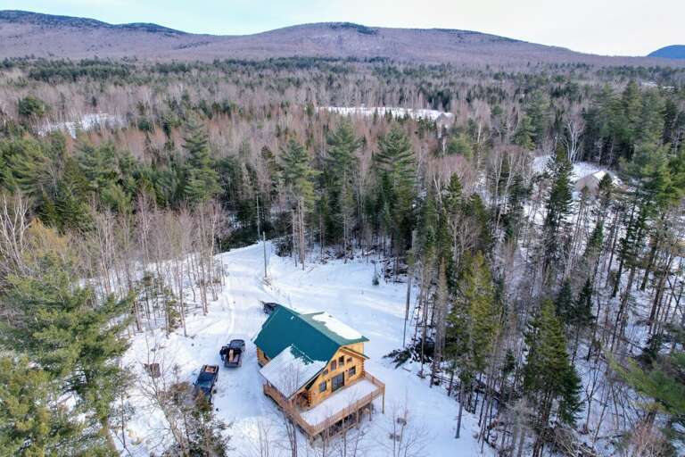 Aerial View Of A Secluded Cabin In Winter Woodland Setting