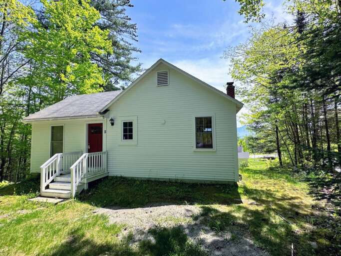 Small White House Surrounded By Trees
