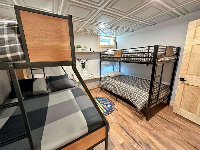 Lower level bunk room with one twin-over-full bunk and one twin-over-twin bunk.