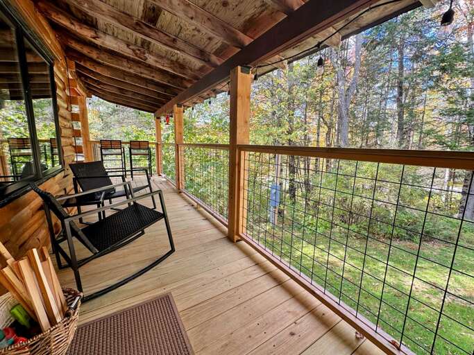 Side deck next to front door, wraps around to larger outdoor deck area