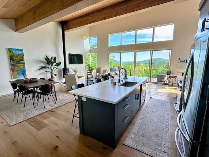 Lovely kitchen, dining, and living space on the main level with large windows and mountain views.