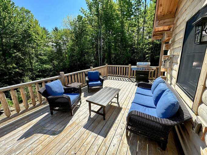 Main level deck with dining table, seating area, and grill