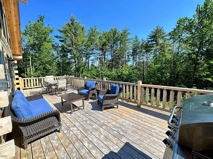 Main level deck with dining table, seating area, and grill
