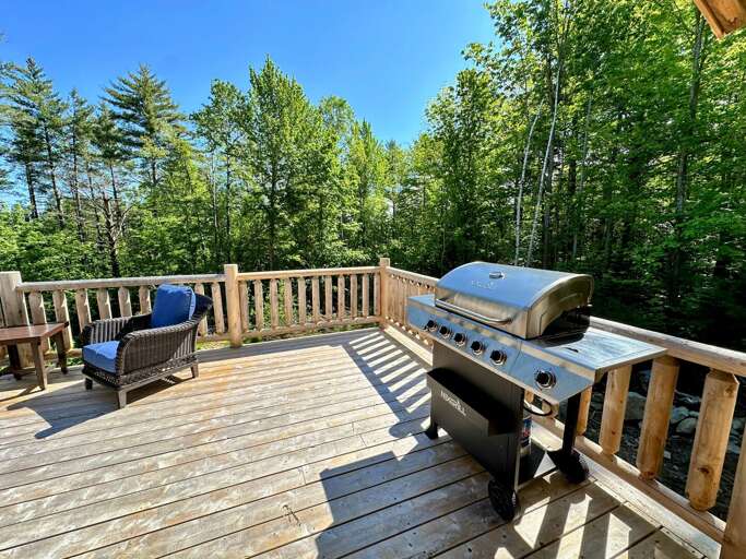 Main level deck with dining table, seating area, and grill