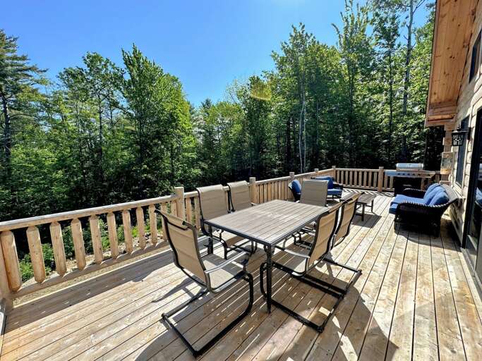 Main level deck with dining table, seating area, and grill