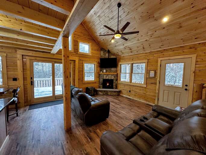 Main Level Living Area with gas fireplace, TV, recliners, and slider access to the deck.