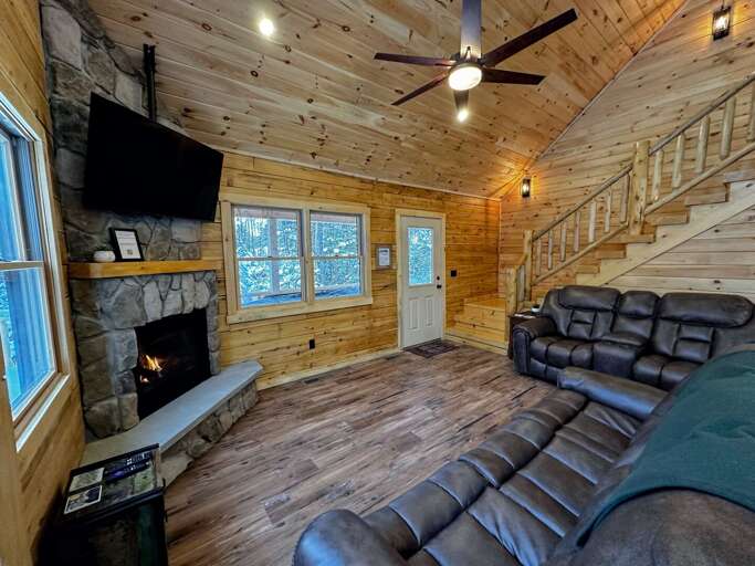 Main Level Living Area with gas fireplace, TV, recliners, and slider access to the deck.