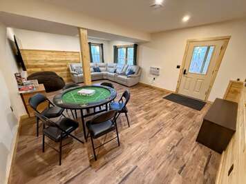 Newly updated Lower Level Common Area with game table, large sectional and TV. This room also is the entrance to the home.