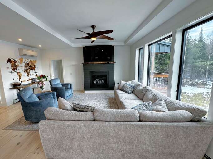 Living Room With Sectional Sofa, Fireplace, And Snow View Outside