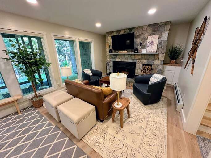 Lower level living area with wood burning fireplace, TV and desk