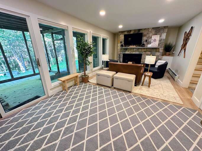 Lower level living area with wood burning fireplace, TV and desk