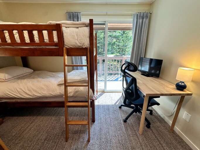 Upper level bunk room with 2 twin-over-twin bunks and a desk